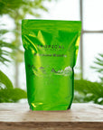 Premium matcha green tea powder pouch on wooden table, surrounded by lush tropical plants