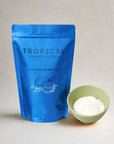 Refreshing coconut latte powder in blue pouch with bowl of white latte powder