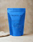 Blue pouch of refreshing coconut latte powder with coconut illustration, beige background