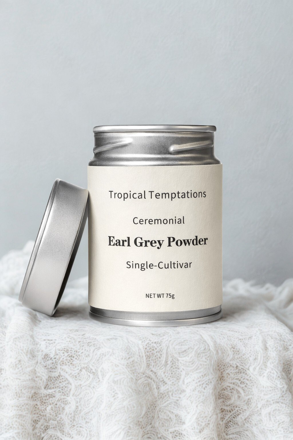 Ceremonial Earl Grey powder tin, silver canister with open lid on soft white fabric